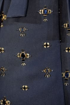 a close up view of a blue tie with gold decorations on it