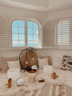 a living room filled with lots of white furniture and pillows on top of a rug