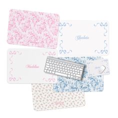 four different colored mousepads and keyboard on top of each other with name tags attached to them