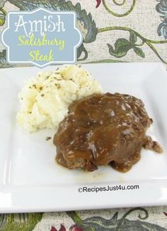 a white plate topped with meat and gravy next to mashed cauliflower