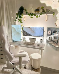 a white chair sitting in front of a desk with two computer monitors on top of it