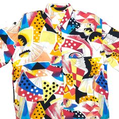 a colorful shirt that is on display in front of a white background with black, yellow, red, and blue designs