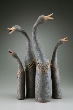 three birds are standing next to each other in front of a gray background with gold trimmings