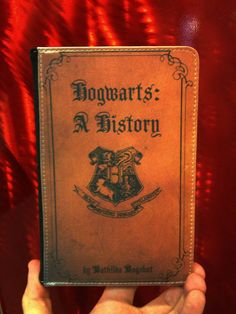 the hogwart's a history book is held in front of a red curtain