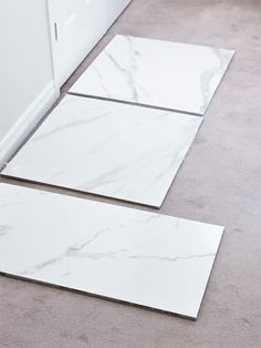 two white marble tiles laying on the floor