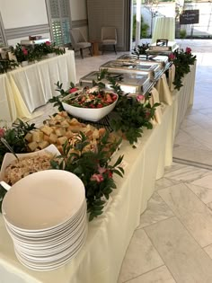 a buffet table filled with lots of food and white plates on top of each plate