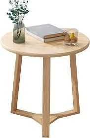 a wooden table with a book, vase and flowers sitting on it's side