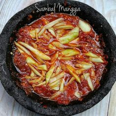 an iron skillet filled with food on top of a wooden table