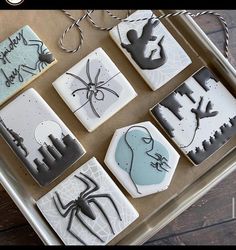 some cookies are decorated with icing and spider webs on them, sitting on a tray