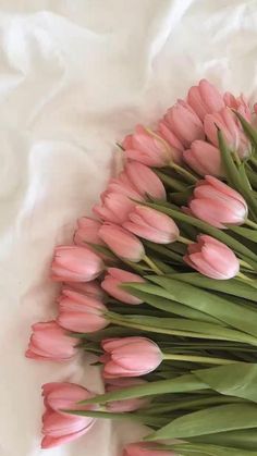 a bouquet of pink tulips on a white sheet