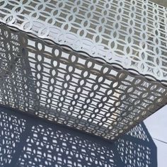 a close up of a metal object on a table with shadows from the light coming through it