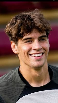 a smiling young man holding a white frisbee