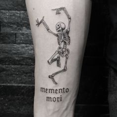 a man with a skeleton tattoo on his leg that says mementoo mori