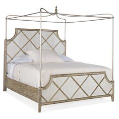 a white bed with a metal frame and headboard