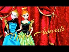 two dolls standing next to each other in front of a red curtain with gold lettering