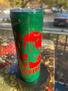 a green and red cup sitting on top of a table next to a parking lot