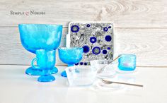 blue glassware is sitting on a white table