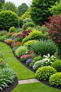 a garden filled with lots of different types of flowers and greenery next to trees