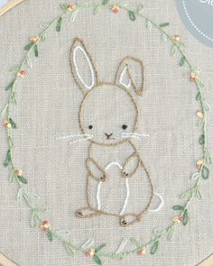 an embroidered bunny sitting in the middle of a hoop