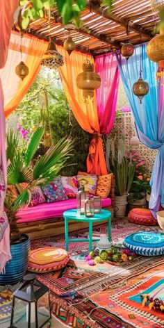 an outdoor area with lots of colorful curtains and rugs on the floor, including a couch