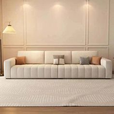 a white couch sitting on top of a wooden floor next to a light colored wall