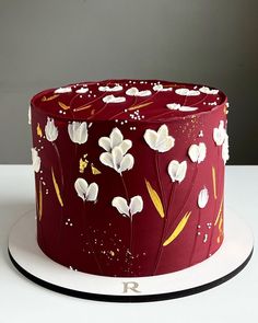 a red cake with white flowers on it