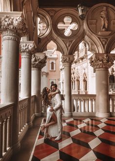 a man and woman are standing in an ornate room with red and white checkered flooring