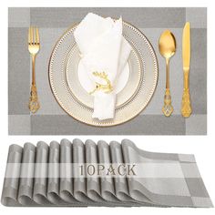 a place setting with napkins, silverware and gold utensils on it