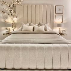 a large bed with white sheets and pillows on it's headboard in a bedroom