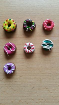 six miniature donuts sitting on top of a wooden table