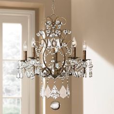 a chandelier hanging from the ceiling in a room with white walls and windows