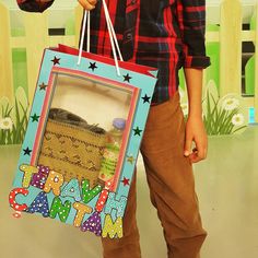 a young boy holding a bag with the words happy birthday written on it and stars