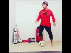 a man in a red shirt kicking a soccer ball