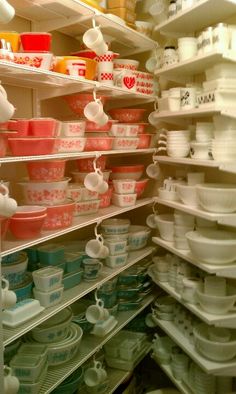 the shelves are filled with dishes and cups