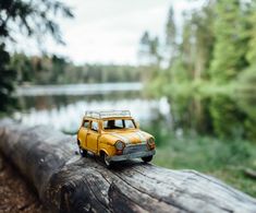 a toy car is sitting on top of a log