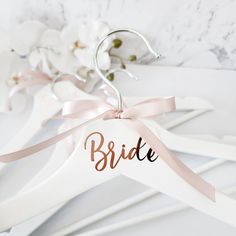 the bride hangers are decorated with pink ribbons