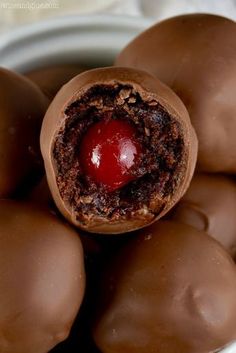 chocolate candies in a white bowl with a cherry on top