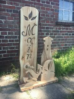 a carved wooden sign sitting in front of a brick building