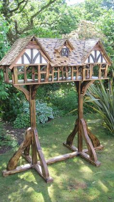 a wooden structure in the middle of some grass