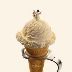 an ice cream cone with two people standing on top, and the image is made from photoshopped images