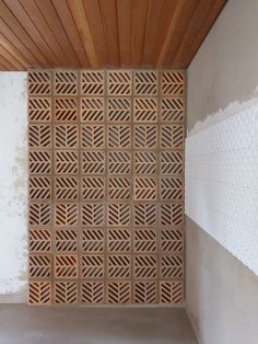 a room with a wall made out of wooden slats and white tiles on the walls