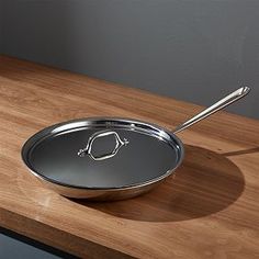 a silver pan sitting on top of a wooden counter next to a knife and fork