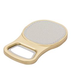 a gold and white electronic device on a white surface with a leather strap around the edge