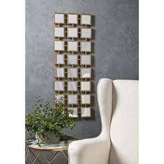 a white chair sitting in front of a mirror on a wall next to a potted plant