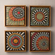 three square paintings with different designs on the wall next to each other in wooden frames