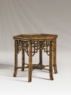 a wooden table with intricate carvings on the top and bottom, against a white background