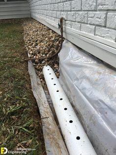 a white pipe laying next to a house