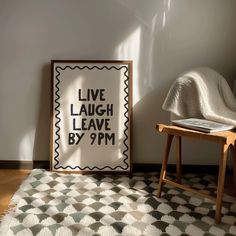 a black and white poster sitting on top of a wooden table next to a chair