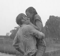 two people hugging each other in the rain