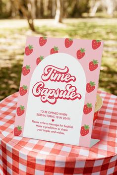 a strawberry themed birthday party with pink and red gingham table cloth, strawberries on the top